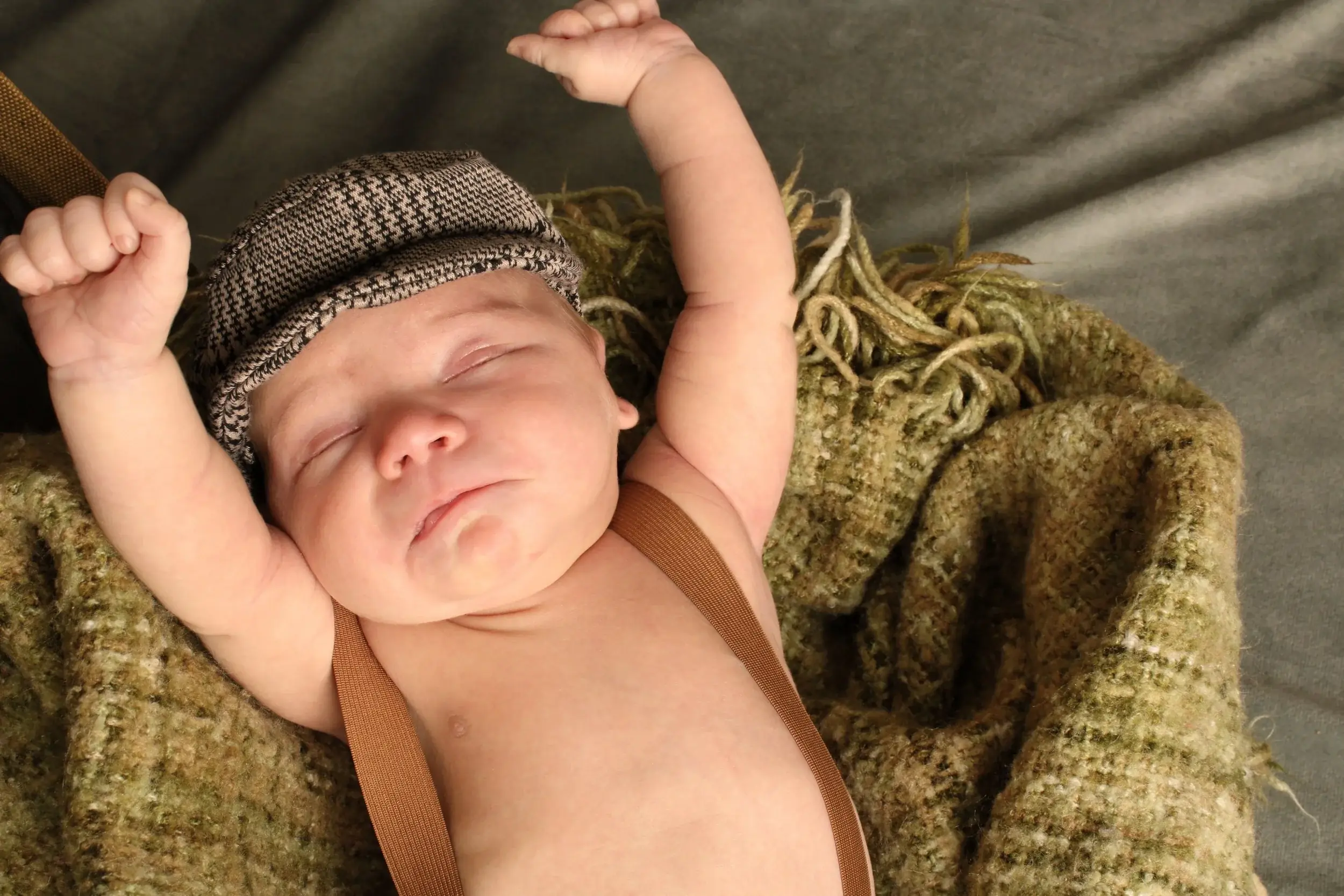 Close-up of a newborn baby boy stretching his arms during a session — serving Baldwin, NY families